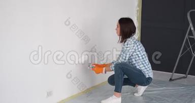 女人用滚筒在内墙涂油漆